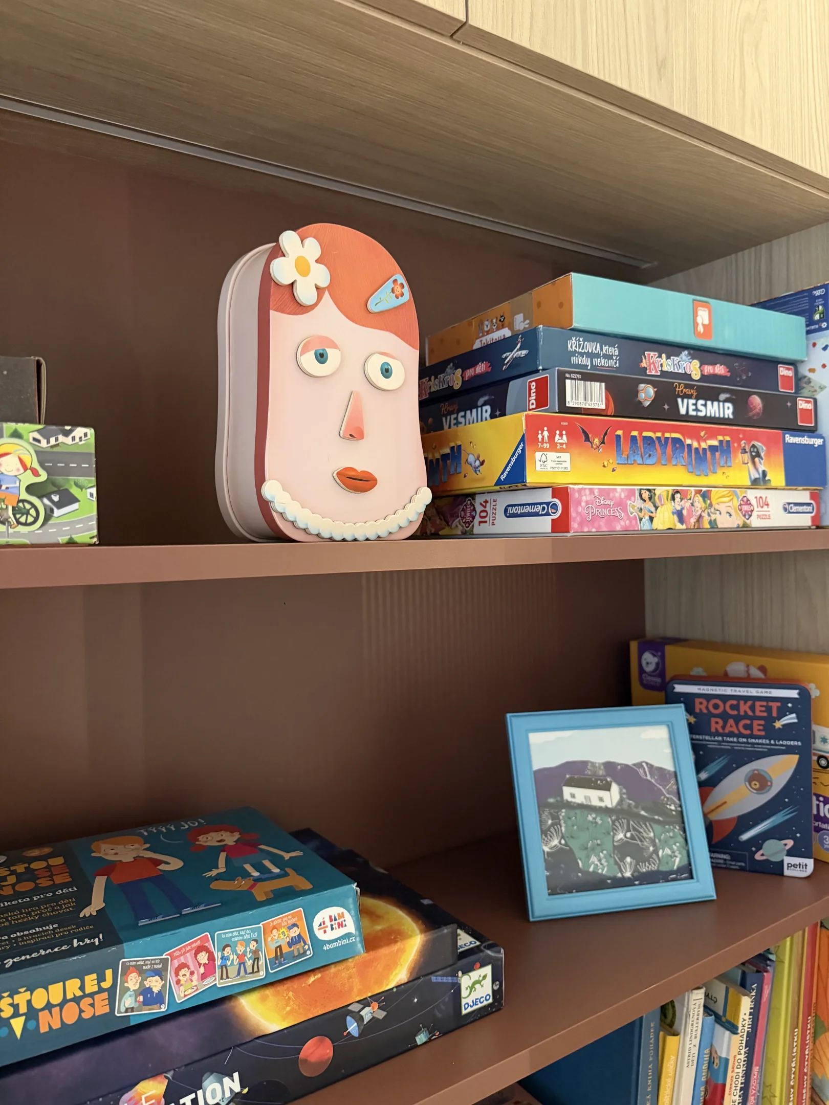 Police plná her knih a dětských hraček v interiéru.